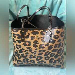 Reversible leopard and black Coach tote with keychain and pouch.